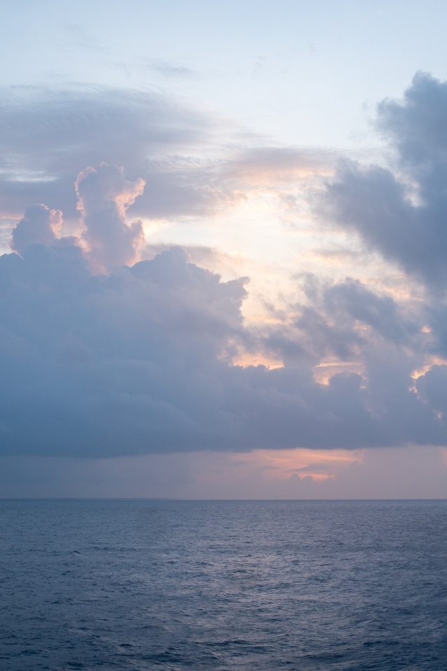 Густые белые облака над морем на рассвете летом