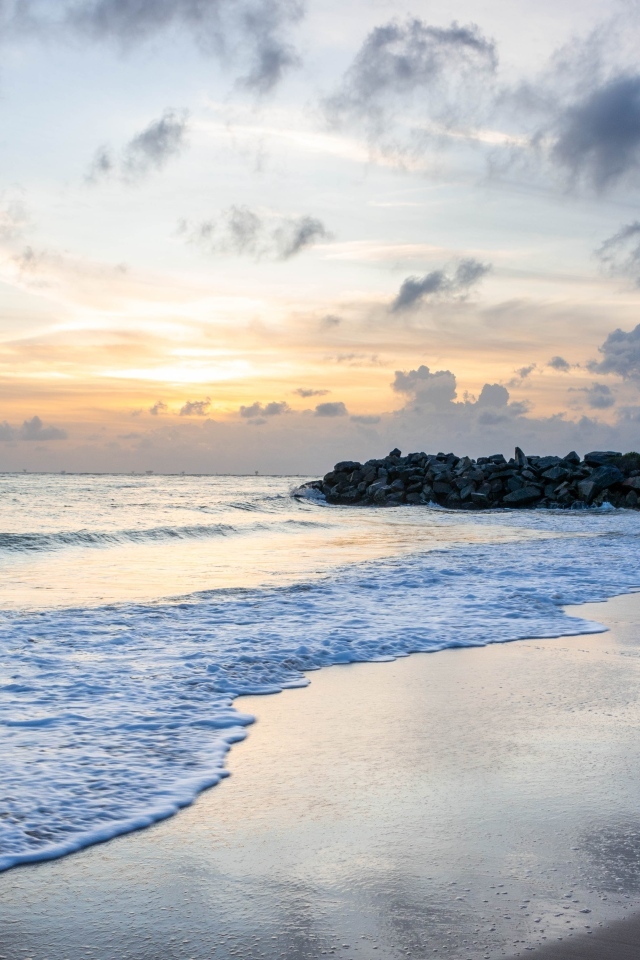 Волны омывают морской песок на рассвете