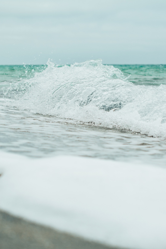 Белая морская пена на морском песке вблизи