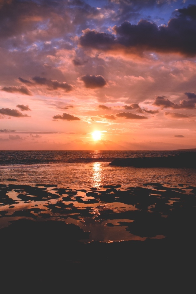 Закат яркого летнего солнца в небе над морем