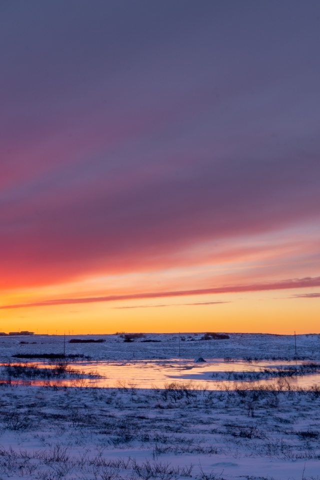 Закат солнца над покрытым снегом полем Аляски