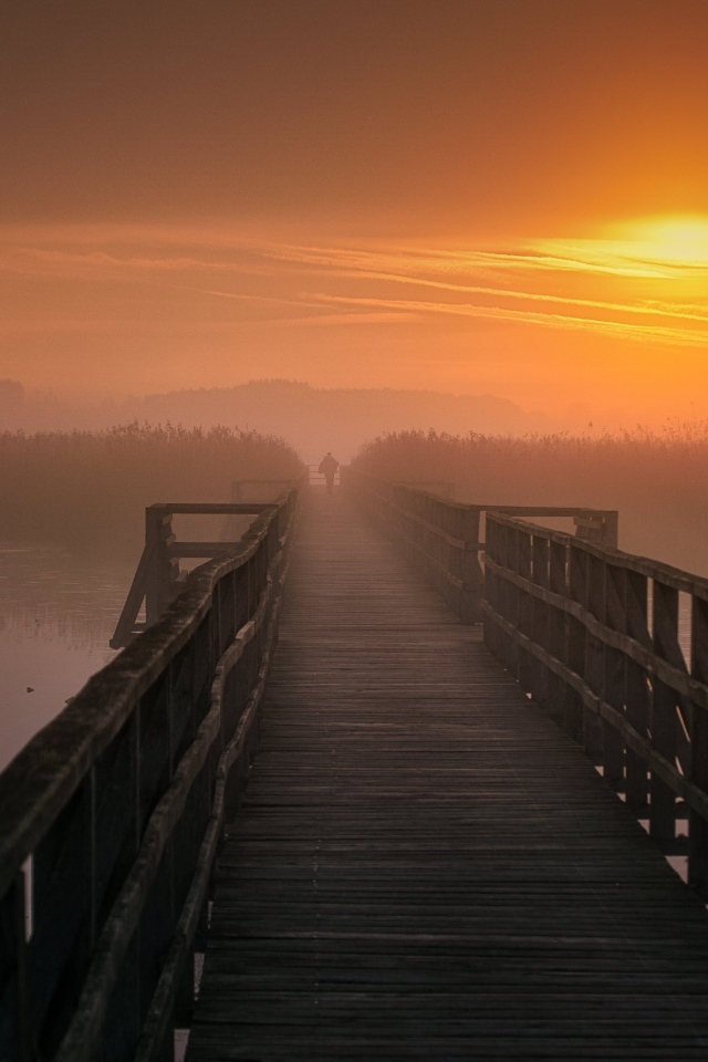 Деревянный мост над рекой на закате