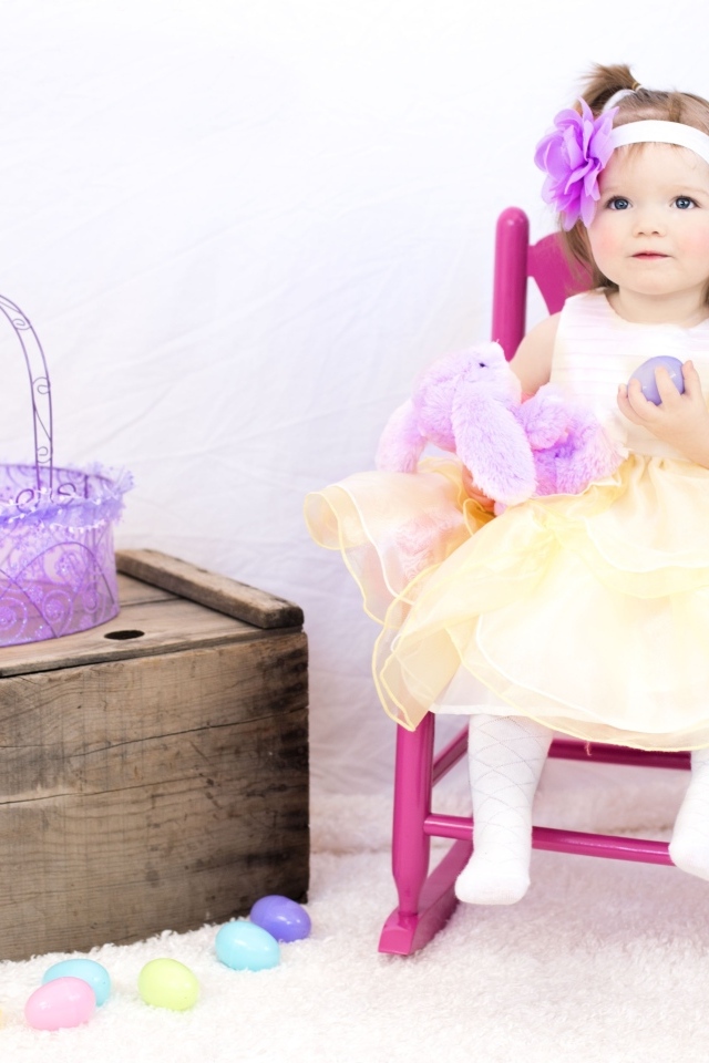 Девочка в красивом платье сидит на стуле 