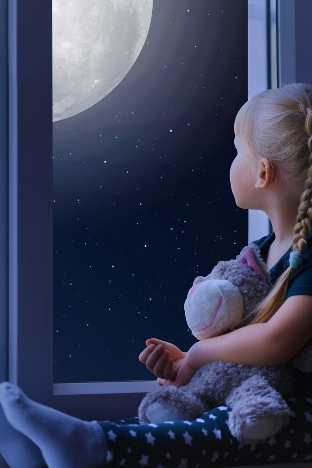 Маленькая девочка с игрушкой смотрит у окна на луну