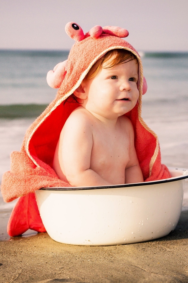 Ребенок в миске на берегу моря