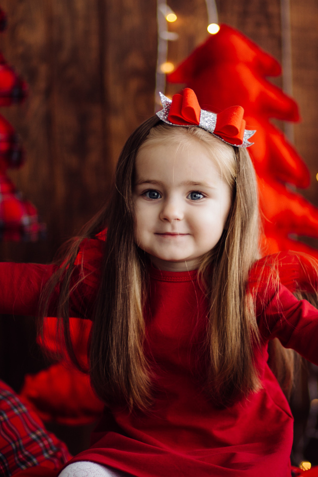 Красивая маленькая длинноволосая девочка в красном платье