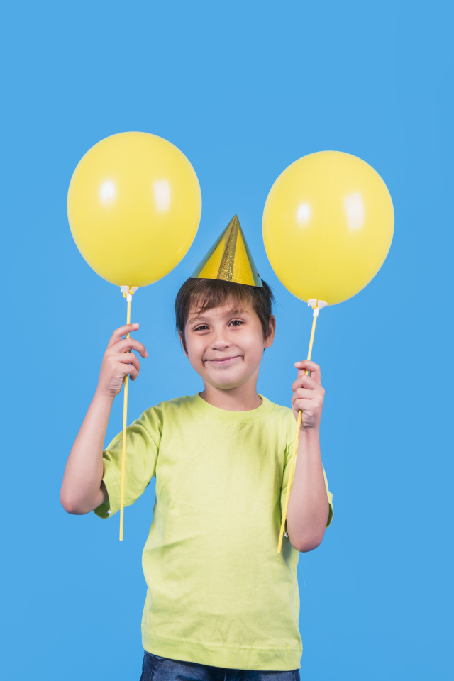 Мальчик на день рождения с желтыми шариками