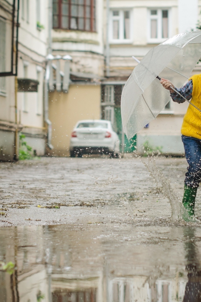 Мальчик с зонтом прыгает по лужам