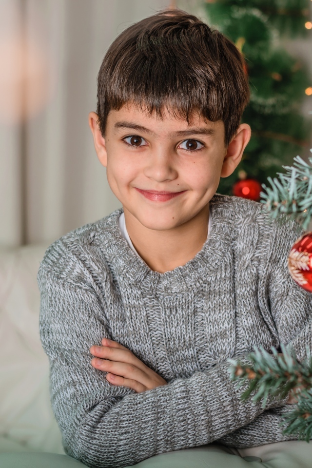 Кареглазый мальчик у новогодней ели