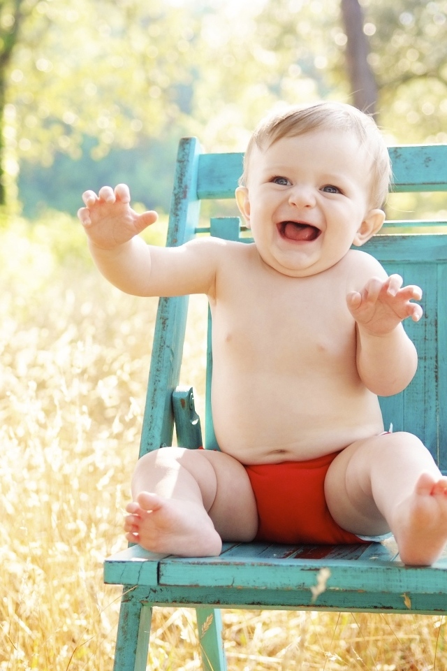 Веселый маленький мальчик в кресле 