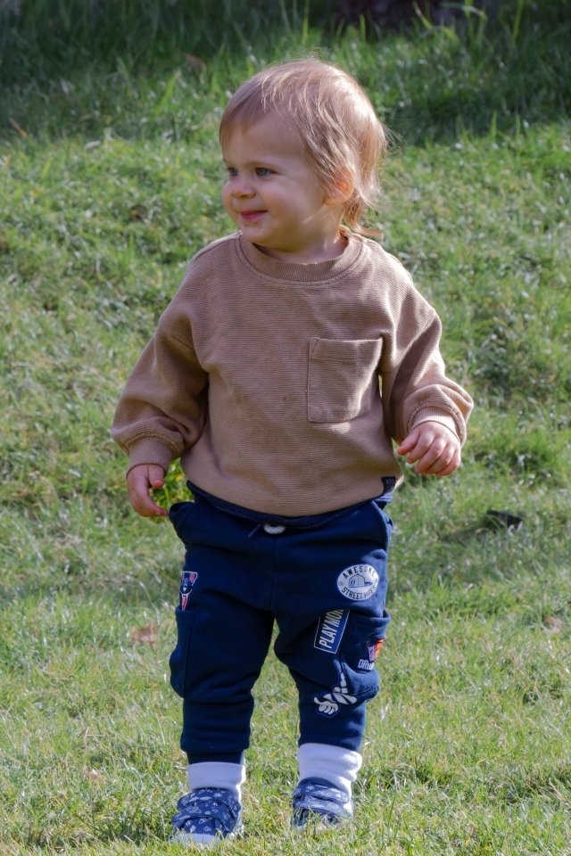 Веселый маленький мальчик гуляет на природе