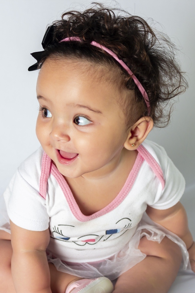 Веселая маленькая девочка с ободком на голове