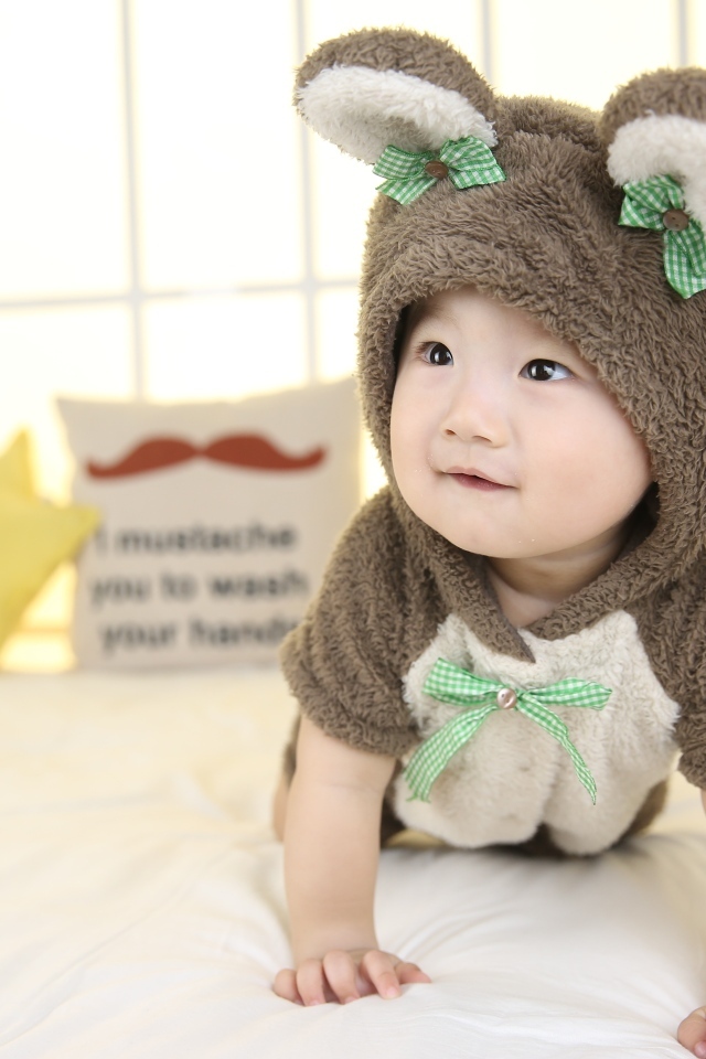 Ребенок в костюме медвежонка на кровати