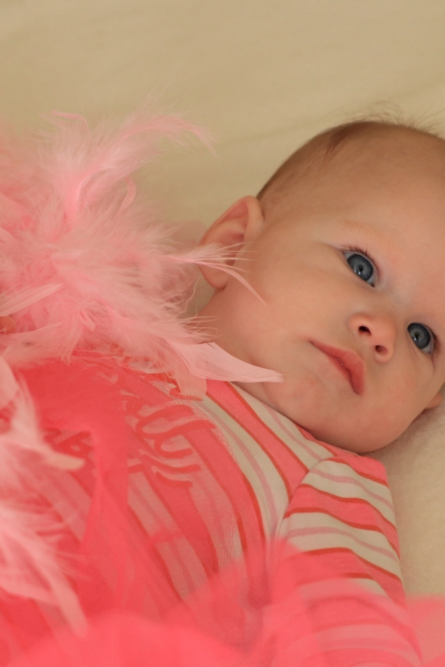 Милая малышка с розовыми перьями