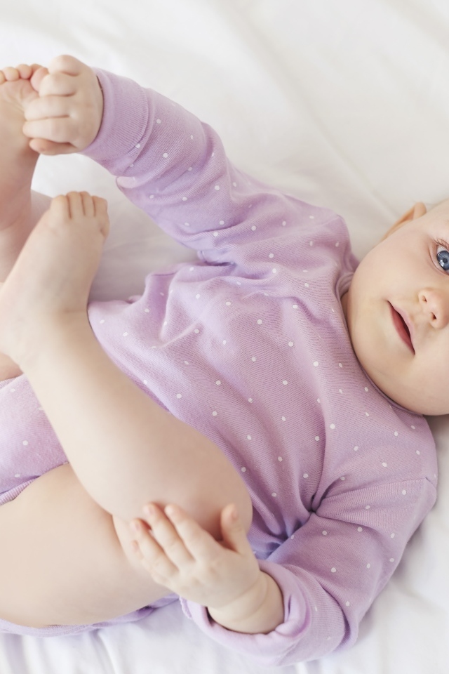 Милый голубоглазый малыш на белом покрывале