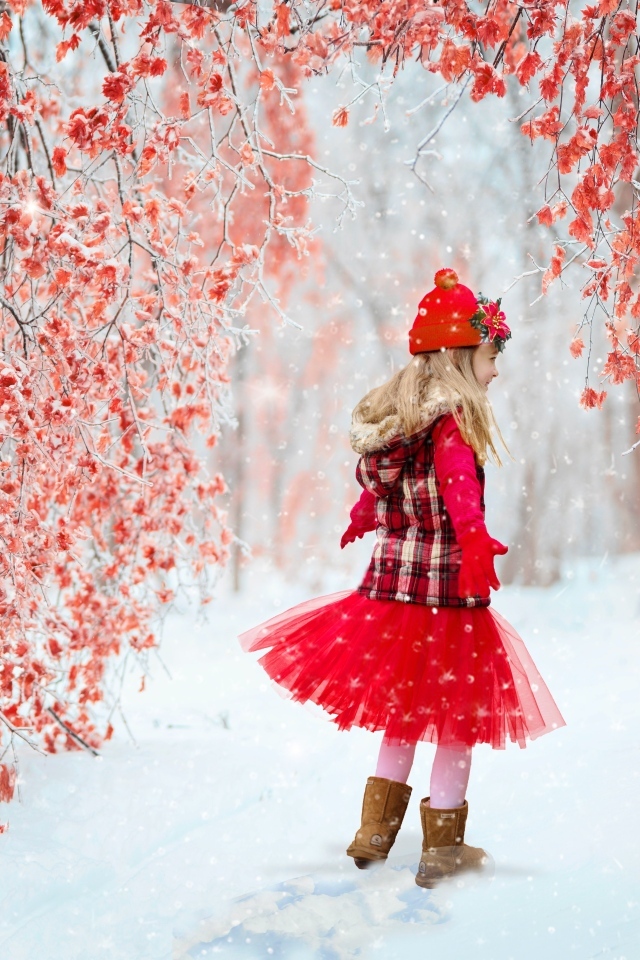 Милая девочка в заснеженном лесу с деревьями с красными листьями