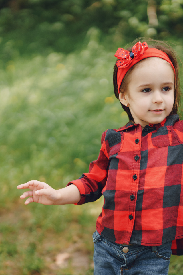 Милая девочка с красным бантом на голове 