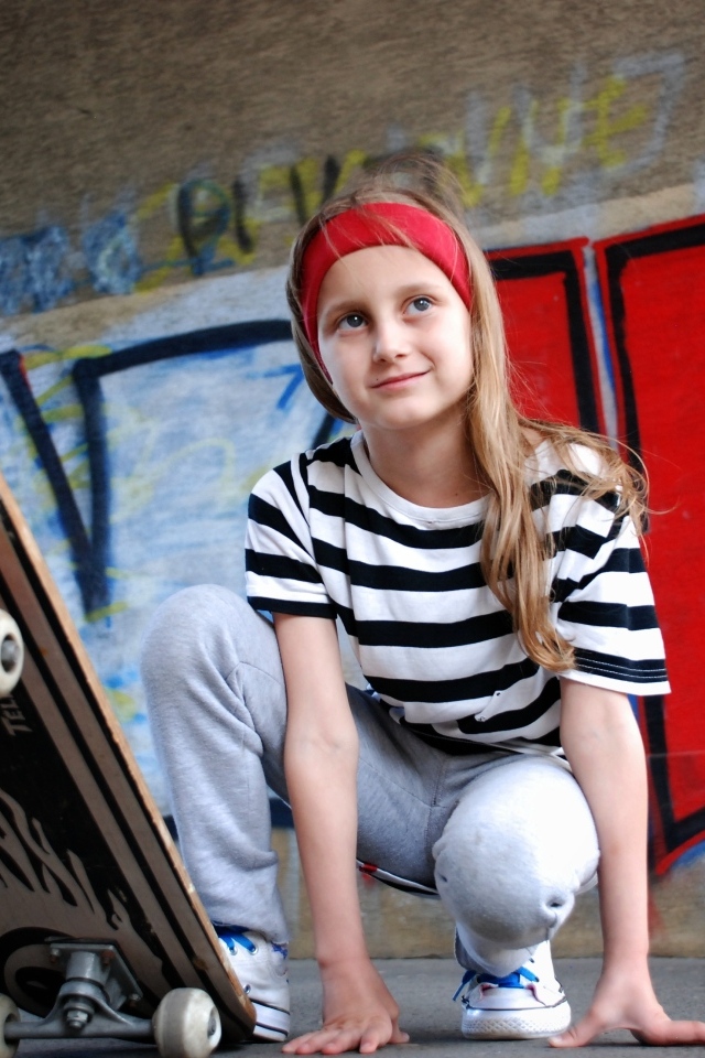 Милая маленькая девочка со скейтбордом