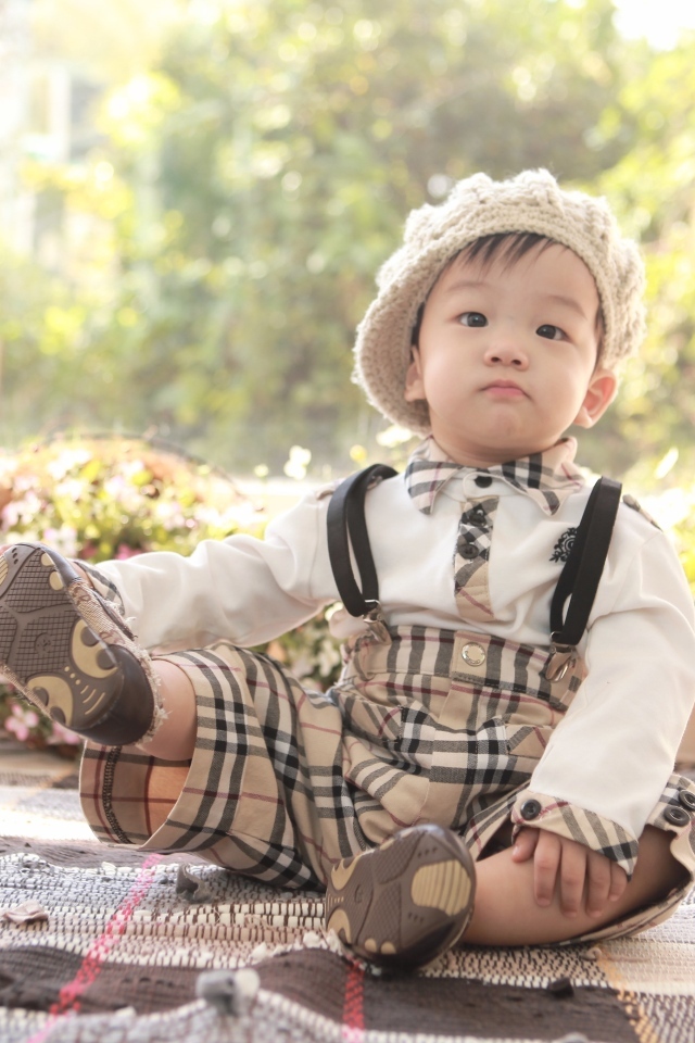 Смешной мальчик азиат у цветов