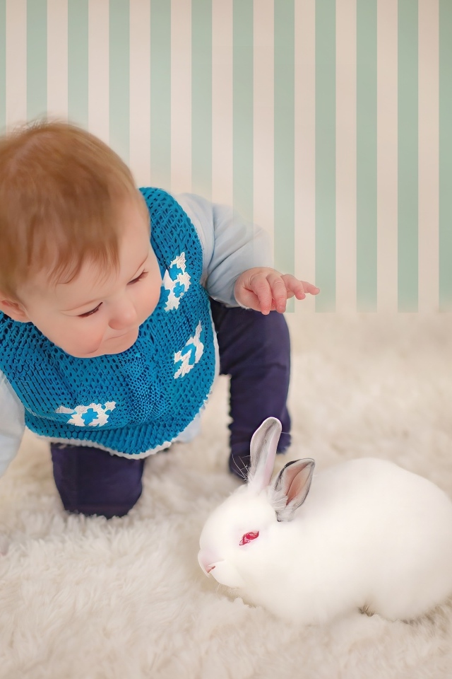 Смешной маленький мальчик с белым кроликом