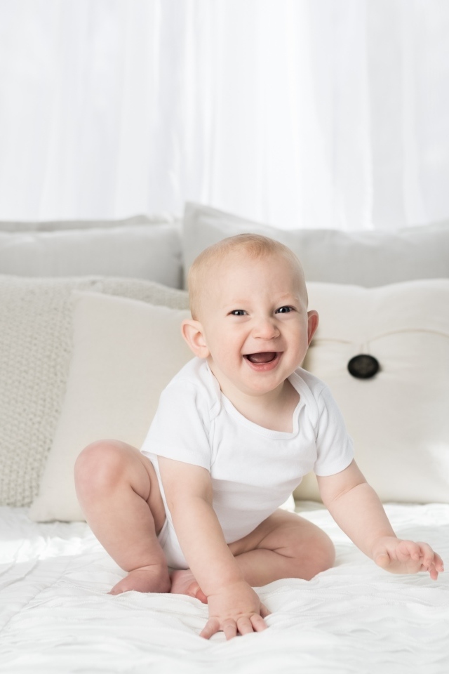 Смешной маленький ребенок на кровати