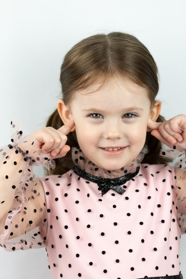 Смешная маленькая девочка закрыла уши