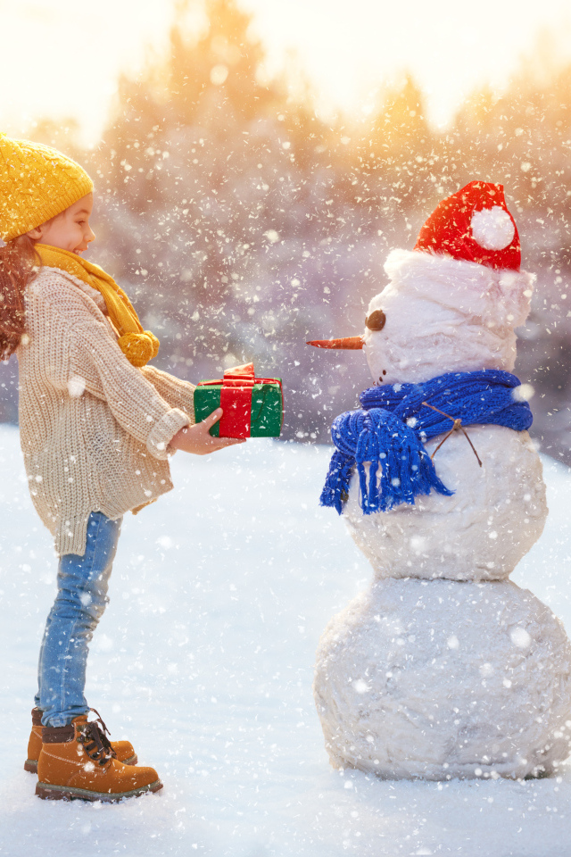 Девочка дарит подарок снеговику