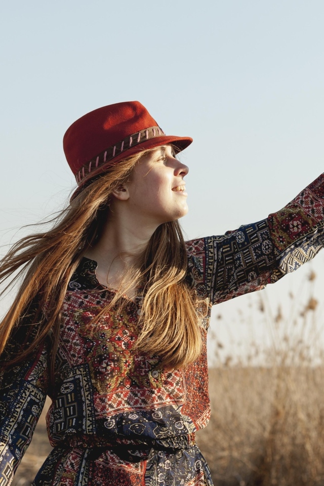 Девочка в шляпе на поле в лучах солнца