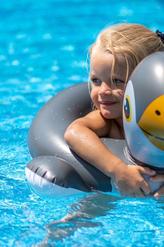 Девочка со спасательным кругом в бассейне