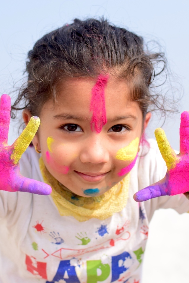 Девочка с руками в краске на празднике