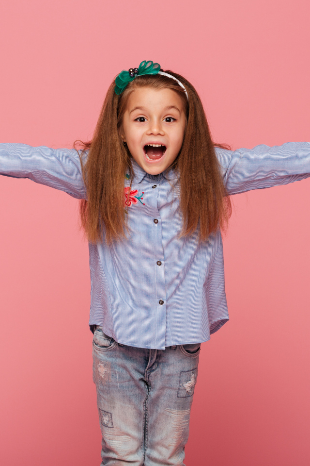 Счастливая маленькая девочка на розовом фоне