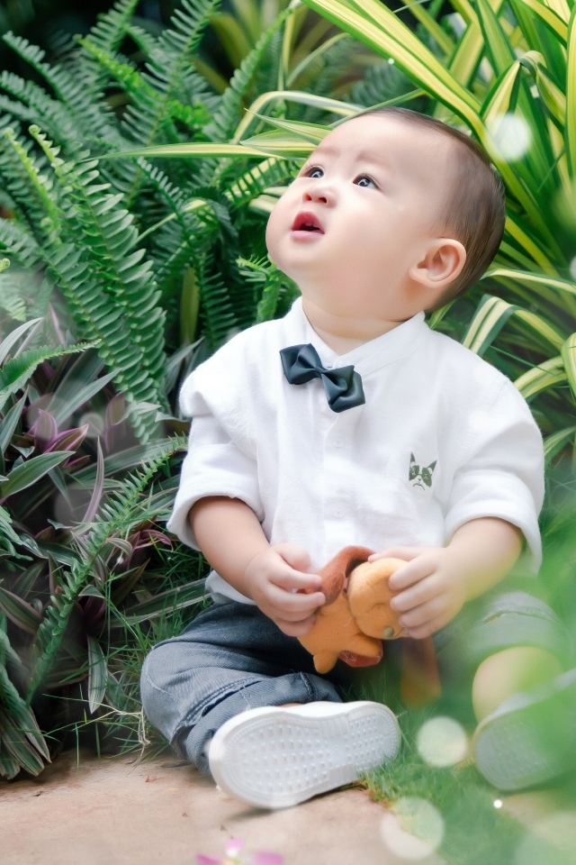 Маленький азиатский ребенок в зеленой траве