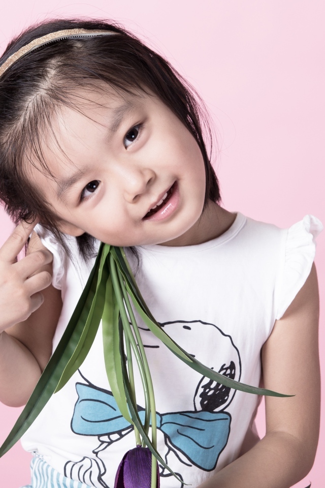 Маленькая девочка азиатка на розовом фоне