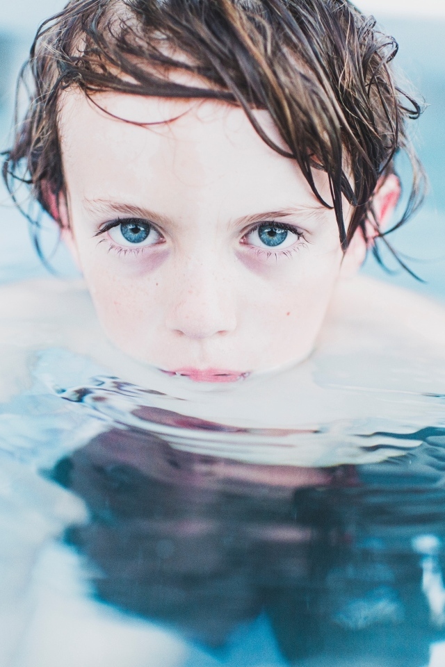 Маленький голубоглазый мальчик в бассейне