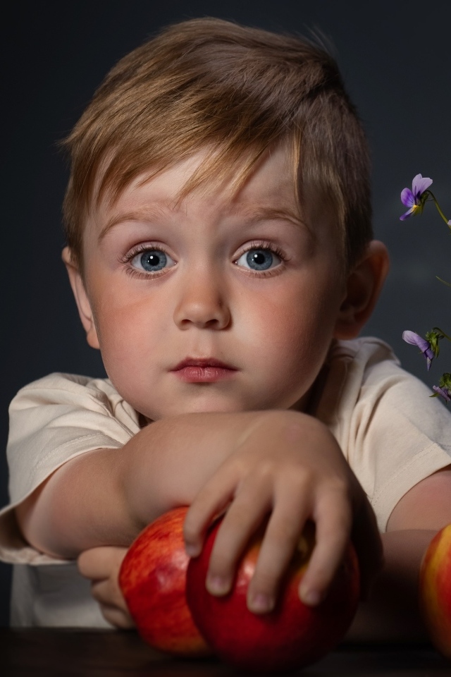 Маленький голубоглазый мальчик с яблоками