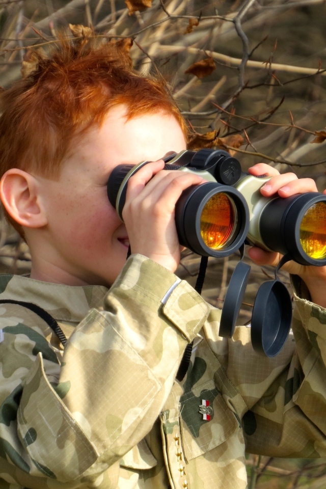 Маленький мальчик в военной форме с биноклем в руках