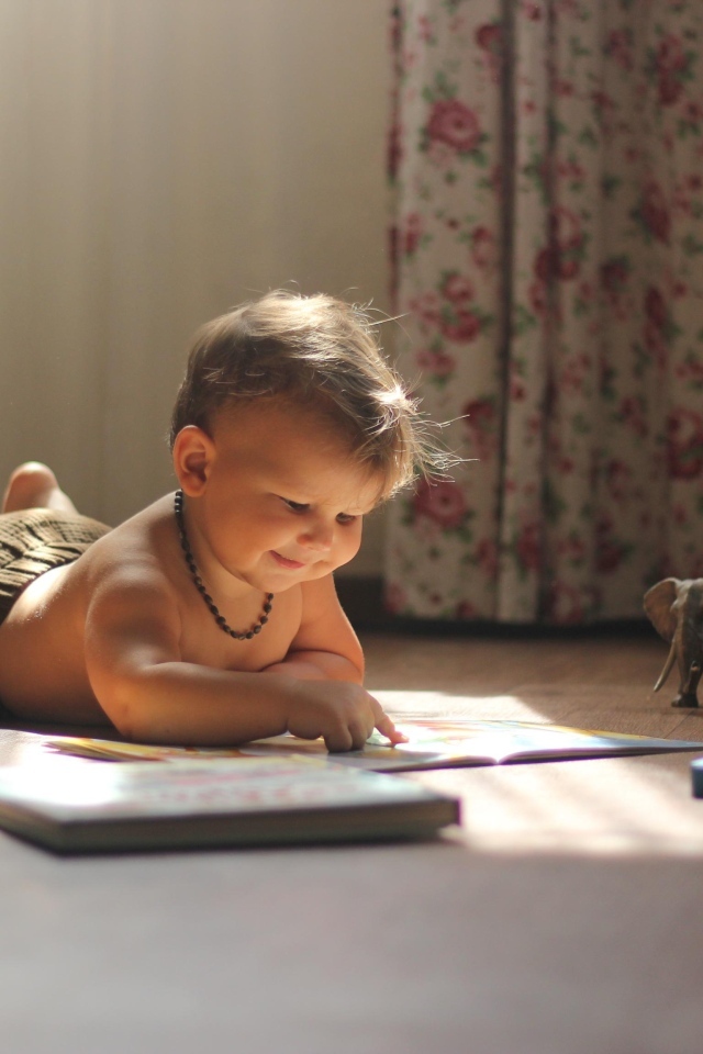 Маленький мальчик с игрушками читает книгу