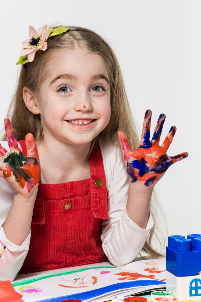 Маленькая девочка рисует красками