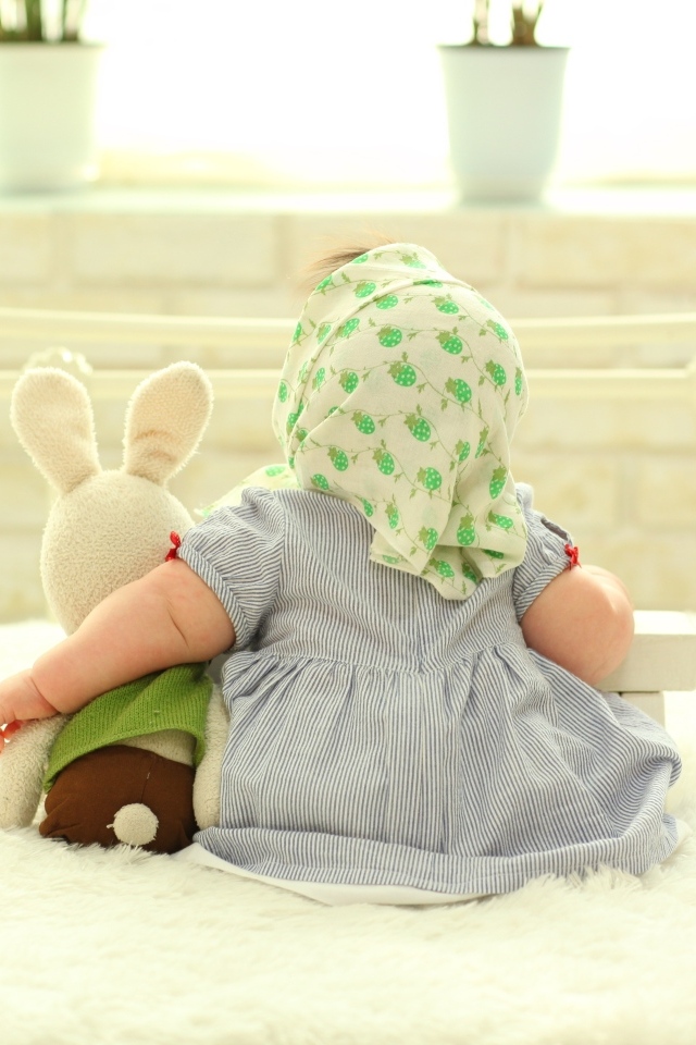 Маленькая девочка сидит с игрушкой