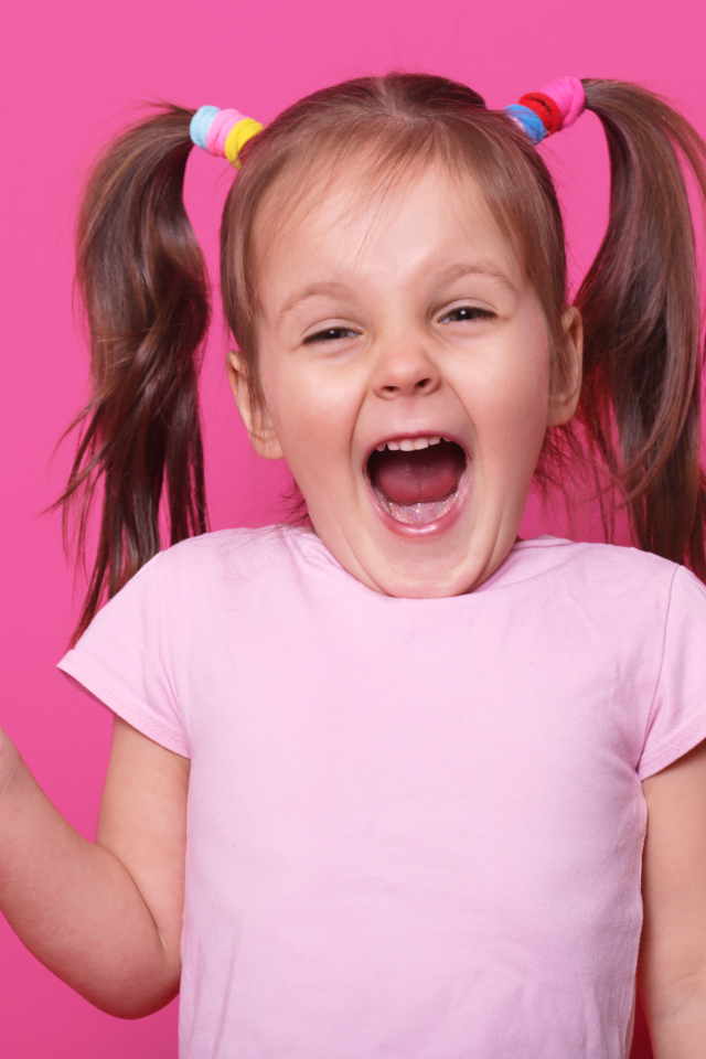 Маленькая девочка с леденцом на розовом фоне