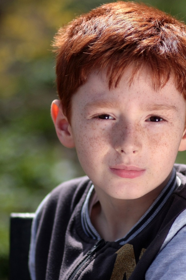 Маленький рыжеволосый мальчик с веснушками на лице