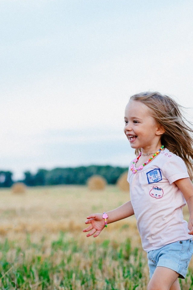 Маленькая улыбающаяся девочка на поле