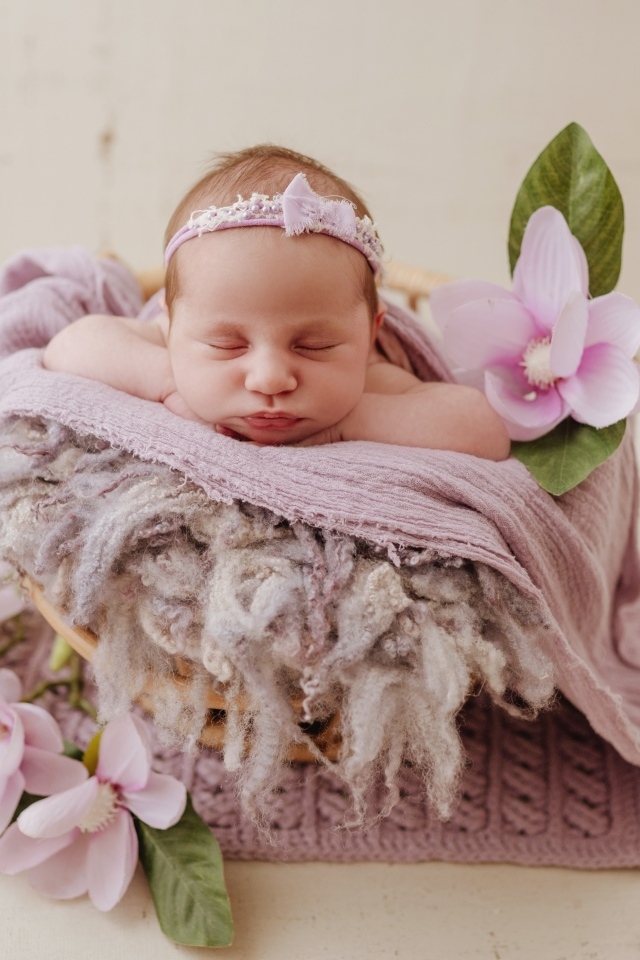 Спящая новорожденная малышка с цветами