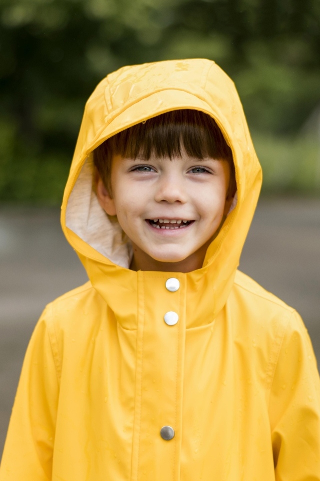 Улыбающийся мальчик в желтой куртке