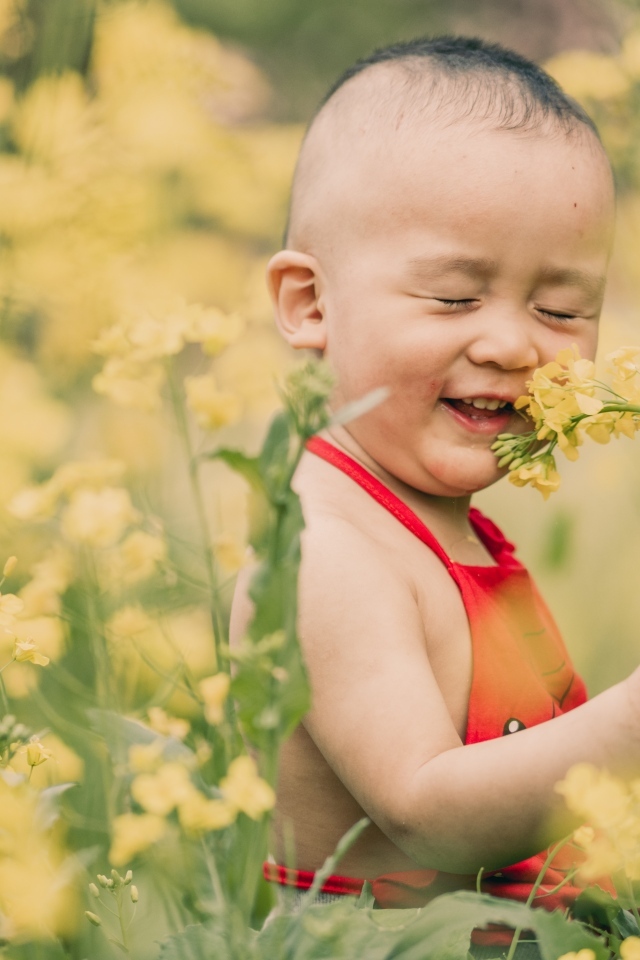 Улыбающийся ребенок на поле с желтыми цветами