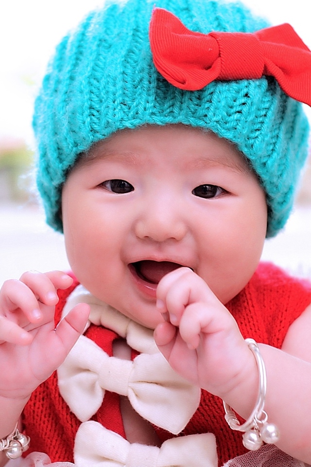 Улыбающаяся девочка в зеленой вязаной шапке