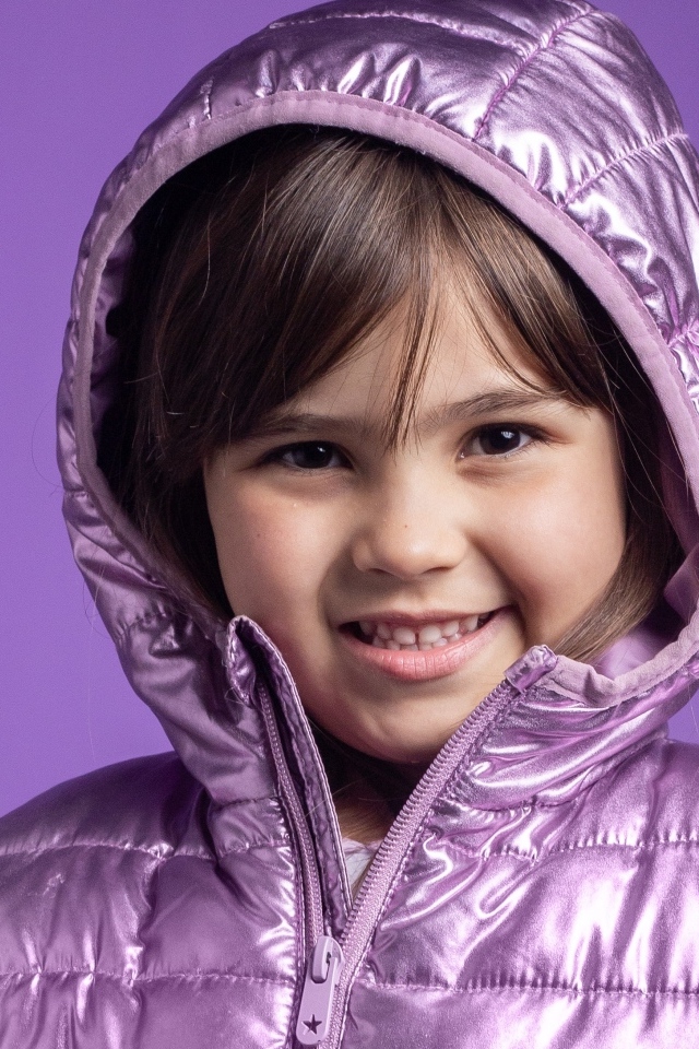 Улыбающаяся девочка в сиреневой куртке