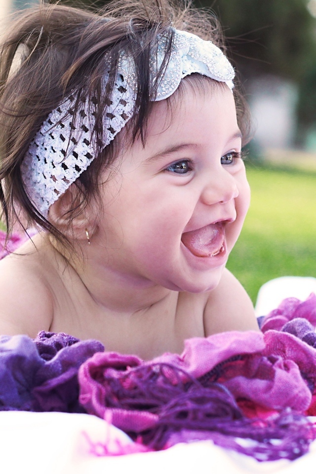 Улыбающаяся маленькая девочка с повязкой на голове 