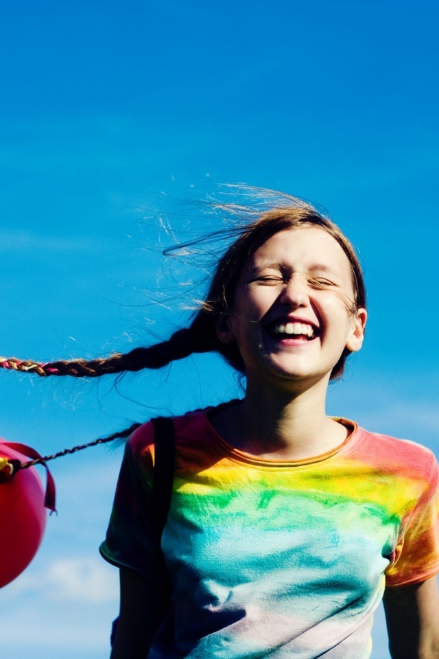 У веселой девочки шарики привязаны к косам