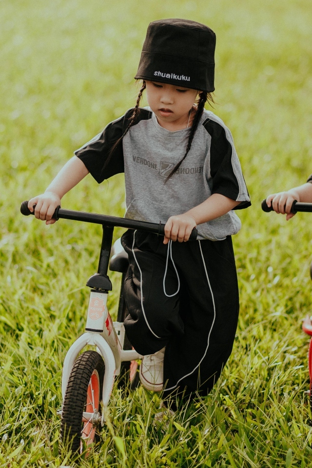Две девочки с велосипедами на зеленой траве